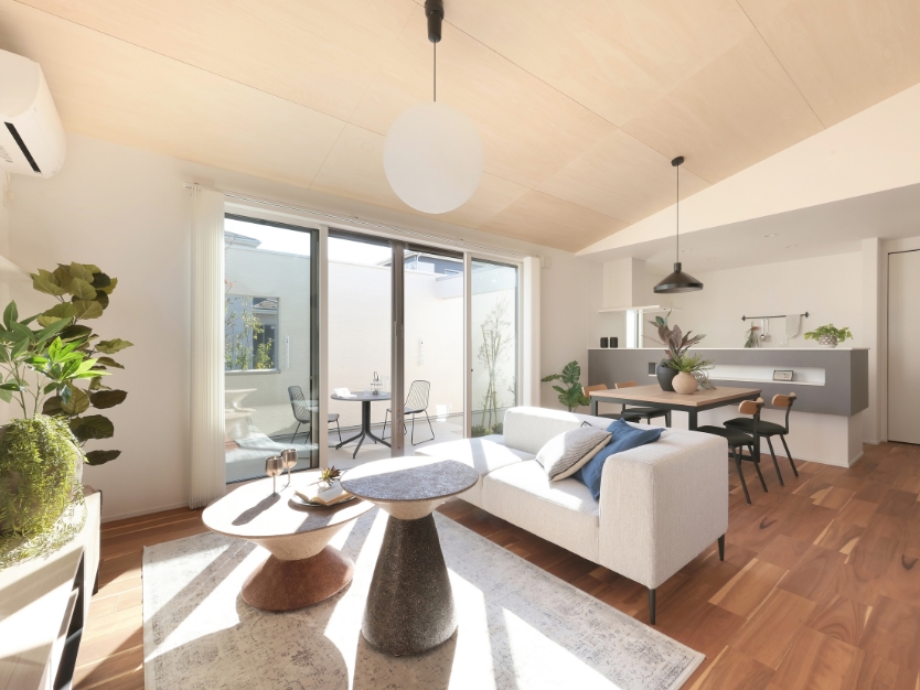 テラスに面して置かれた肘掛けのないグレーのソファ。窓の外への視線が抜け、室内と屋外が繋がるような開放的なリビング空間。