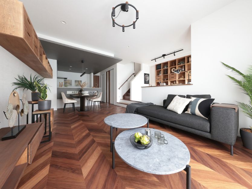 グレーの下がり天井と間接照明が印象的なダイニングキッチン。ヘリンボーンの床にダイニングセットが置かれている。