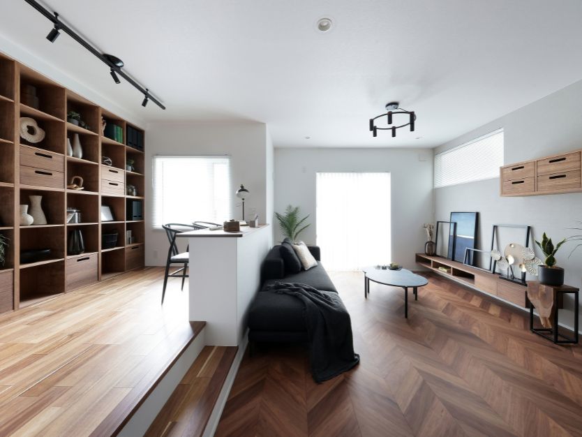 本や装飾品、引き出しが並ぶ、床から天井までの大きな木製グリッドシェルフ（格子棚）。