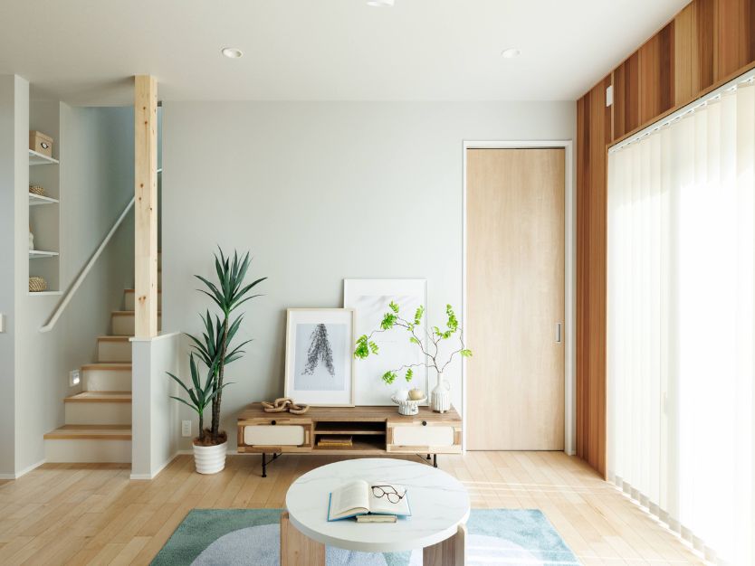 リビングルームに置かれた木製テレビボードと観葉植物、奥に見える階段と木目調のドア